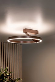 Moderne LED-Deckenleuchte in Ringform mit Holzoptik und warmweißem Licht, an der Decke montiert, Perspektive leicht von unten im Innenraum.