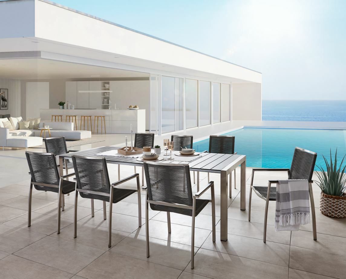 Amatio Ausziehtisch GIRONA Moderner Ausziehtisch auf einer Terrasse mit Meerblick, umgeben von stilvollen Stühlen, aus der Perspektive von schräg oben fotografiert.