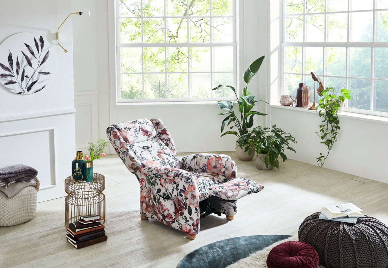 Gemütlicher Fernsehsessel mit floralem Muster in einem hellen Wohnzimmer, seitliche Perspektive