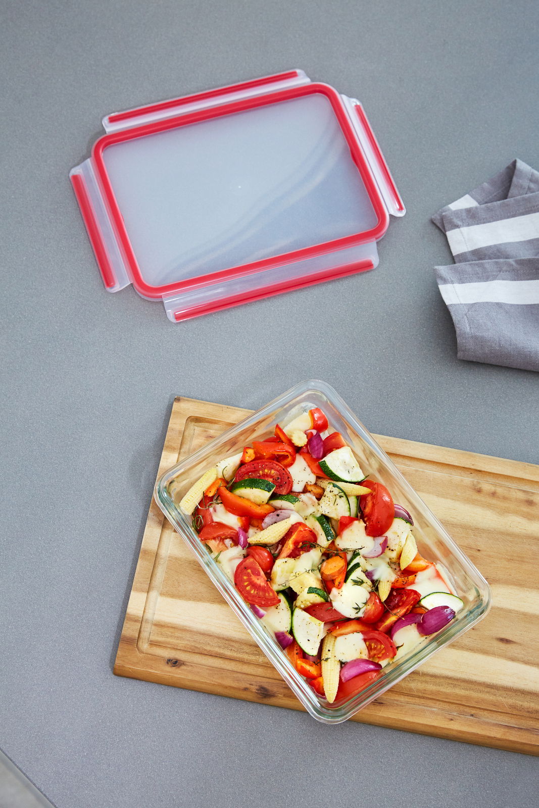 Rechteckige Glasform mit 3,00L Fassungsvermögen, gefüllt mit frischem Gemüse, auf einem Holzbrett von oben fotografiert. Der Deckel liegt daneben.