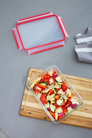 Rechteckige Glasform mit 3,00L Fassungsvermögen, gefüllt mit frischem Gemüse, auf einem Holzbrett von oben fotografiert. Der Deckel liegt daneben.