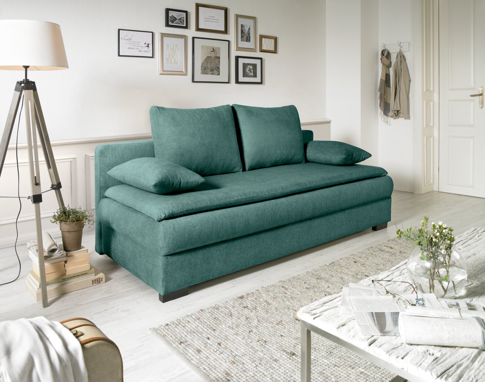 Grünes Funktionssofa in einem stilvoll eingerichteten Wohnzimmer, seitliche Perspektive