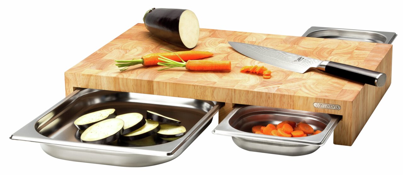 Multifunktionsbrett aus Holz mit drei herausziehbaren Edelstahl-Schalen, darauf ein Messer, Karotten und Auberginen, seitliche Perspektive
