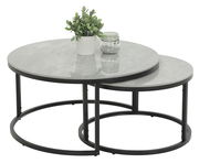 Zweier-Set Couchtische mit runden, grauen Tischplatten und schwarzen Metallgestellen, von schräg oben fotografiert. Auf dem größeren Tisch steht eine Pflanze und ein Glas mit Dekosteinen.
