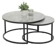 Zweier-Set Couchtische mit runden, grauen Tischplatten und schwarzen Metallgestellen, von schräg oben fotografiert. Auf dem größeren Tisch steht eine Pflanze und ein Glas mit Dekosteinen.
