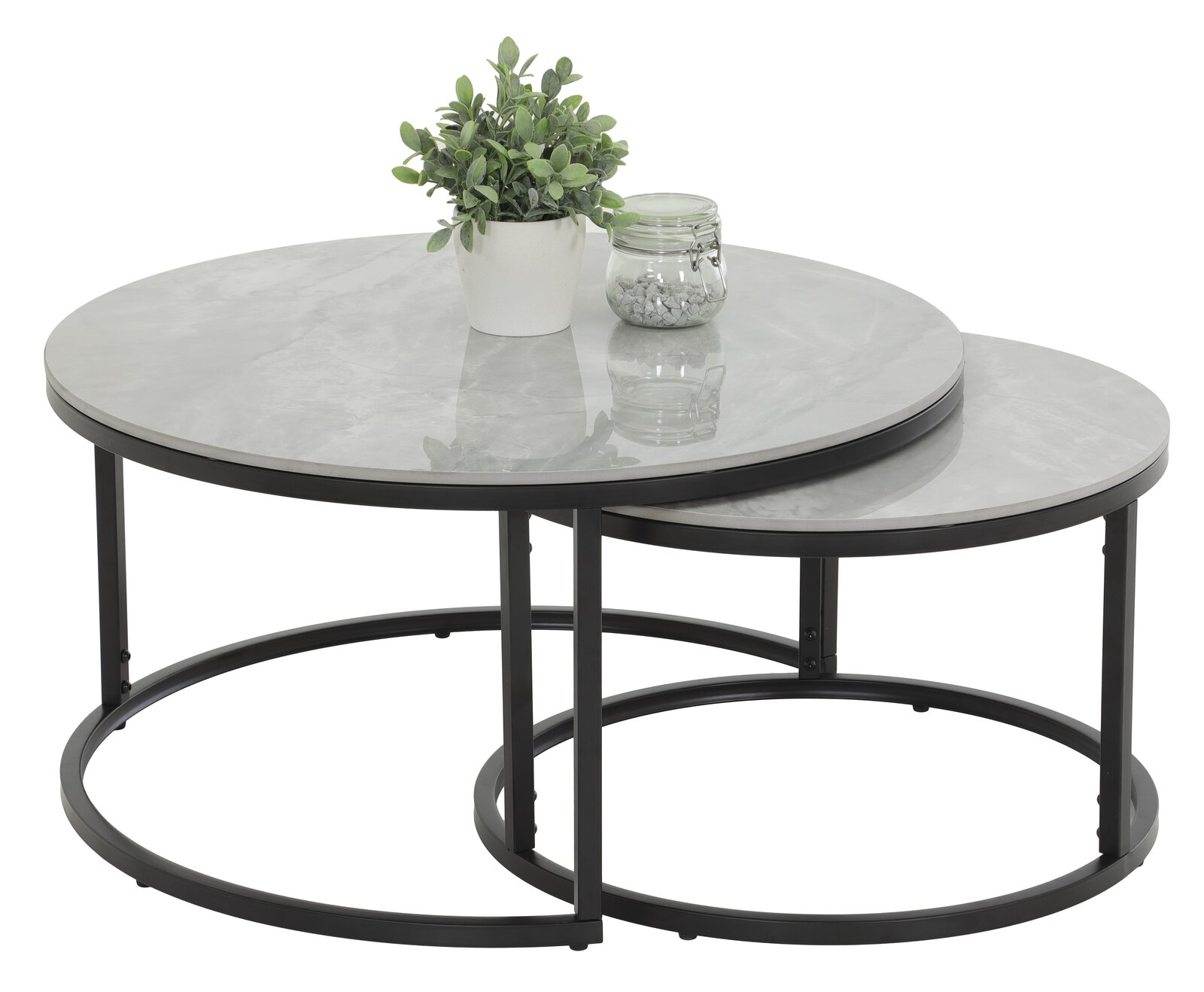 Zweier-Set Couchtische mit runden, grauen Tischplatten und schwarzen Metallgestellen, von schräg oben fotografiert. Auf dem größeren Tisch steht eine Pflanze und ein Glas mit Dekosteinen.