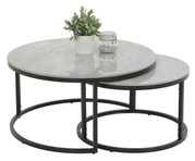Zweier-Set Couchtische mit runden, grauen Tischplatten und schwarzen Metallgestellen, von schräg oben fotografiert. Auf dem größeren Tisch steht eine Pflanze und ein Glas mit Dekosteinen.
