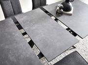 Moderner Esstisch mit grauer, erweiterbarer Tischplatte aus der Vogelperspektive, umgeben von grauen Stühlen.