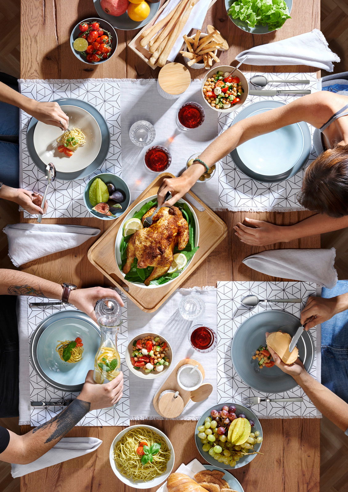Vogelperspektive auf einen gedeckten Tisch mit verschiedenen Speisen und dem Besteck King 60-tlg. poliert.