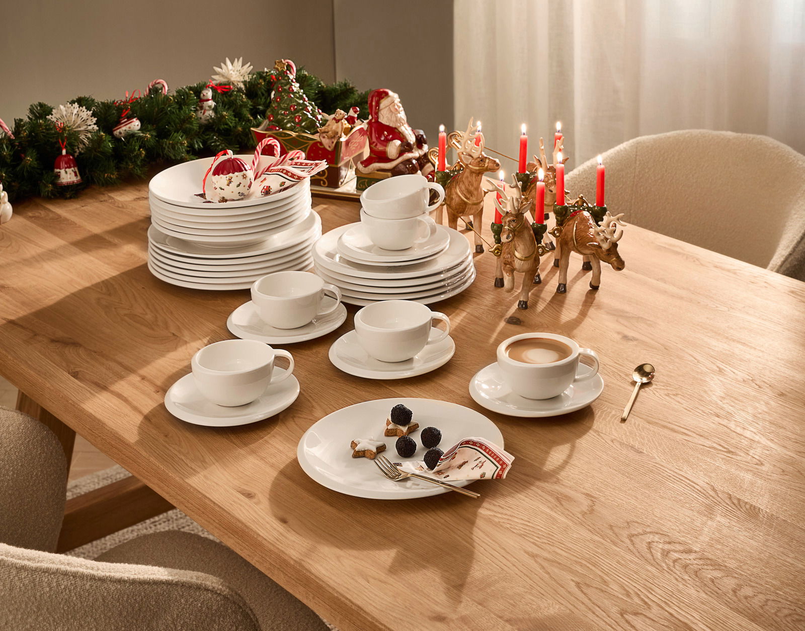 Villeroy & Boch Dinner-Set 12-tlg. NEW MOON Ein festlich gedeckter Tisch mit einem 12-teiligen Dinner-Set, bestehend aus weißen Tellern und Tassen, dekoriert mit weihnachtlichen Elementen wie Kerzen und Rentierfiguren. Perspektive von oben.