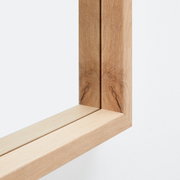 Nahaufnahme eines Holzrahmens eines Spiegels aus der Perspektive der Ecke.