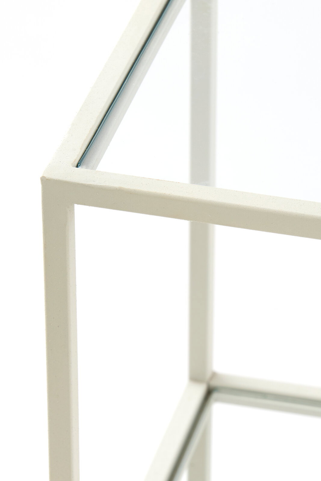 Nahaufnahme eines weißen Konsolentischs mit Glasplatte, Perspektive von oben.