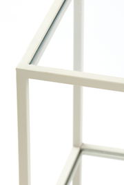 Nahaufnahme eines weißen Konsolentischs mit Glasplatte, Perspektive von oben.