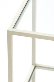 Close-up van een witte consoletafel met glazen blad, gezien van bovenaf.