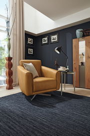 Moderner Drehsessel in senfgelber Farbe, seitliche Perspektive, in einem stilvoll eingerichteten Wohnzimmer mit dunkler Wand und Holzmöbeln.