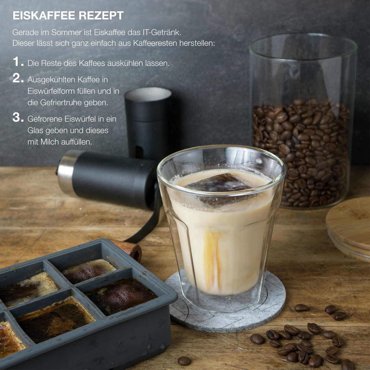 Eiswürfelform mit gefrorenem Kaffee und Glas mit Eiskaffee auf einem Holztisch, seitliche Perspektive.