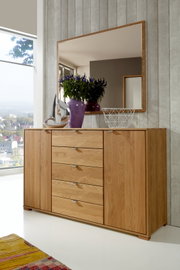 Schubkastenkommode aus Holz mit fünf Schubladen und zwei Türen, dekoriert mit einer lila Vase und einem silbernen Segelboot, aus der Frontalperspektive fotografiert.