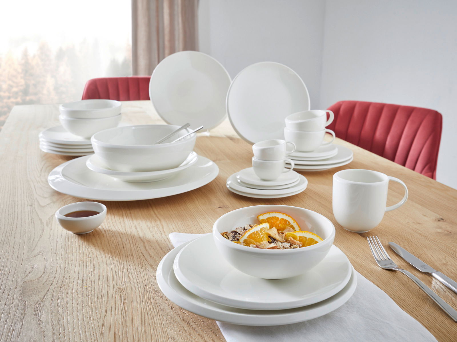 Frühstücks-Set, 6-tlg., auf einem Holztisch arrangiert, mit weißem Geschirr, Tassen und Schalen, seitliche Perspektive.