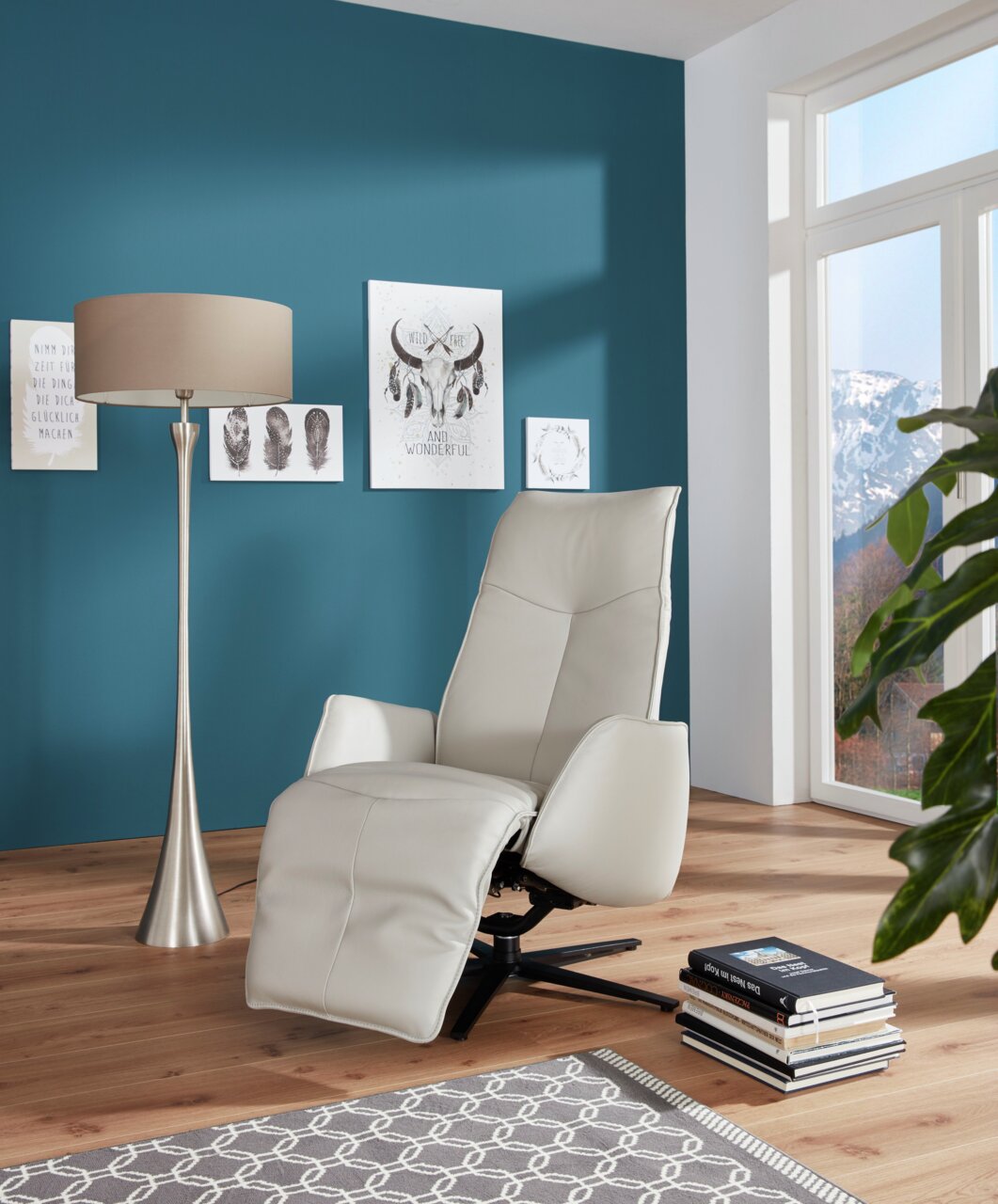 Moderner Fernsehsessel in hellem Leder, seitliche Perspektive, in einem stilvoll eingerichteten Wohnzimmer mit blauer Wand und großen Fenstern.