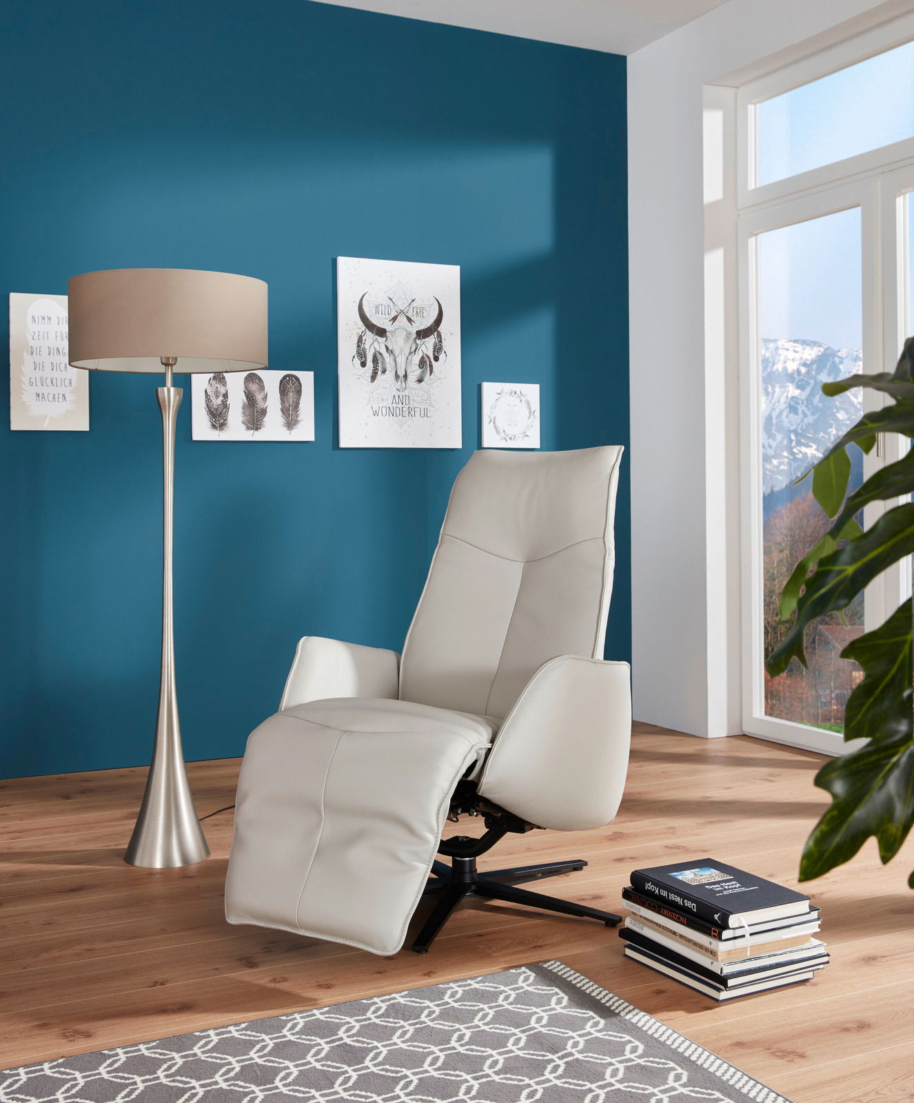 Moderner Fernsehsessel in hellem Leder, seitliche Perspektive, in einem stilvoll eingerichteten Wohnzimmer mit blauer Wand und großen Fenstern.