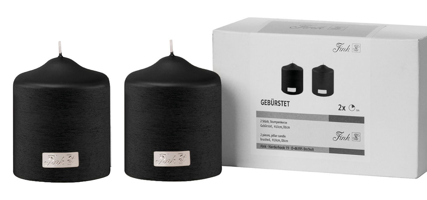Zwei schwarze, gebürstete Stumpenkerzen mit silbernem Emblem, präsentiert in einer Verpackung. Frontalansicht.