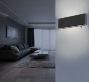 Moderne schwarze Aluminium-Wandleuchte in einem stilvollen Wohnzimmer, seitliche Perspektive.