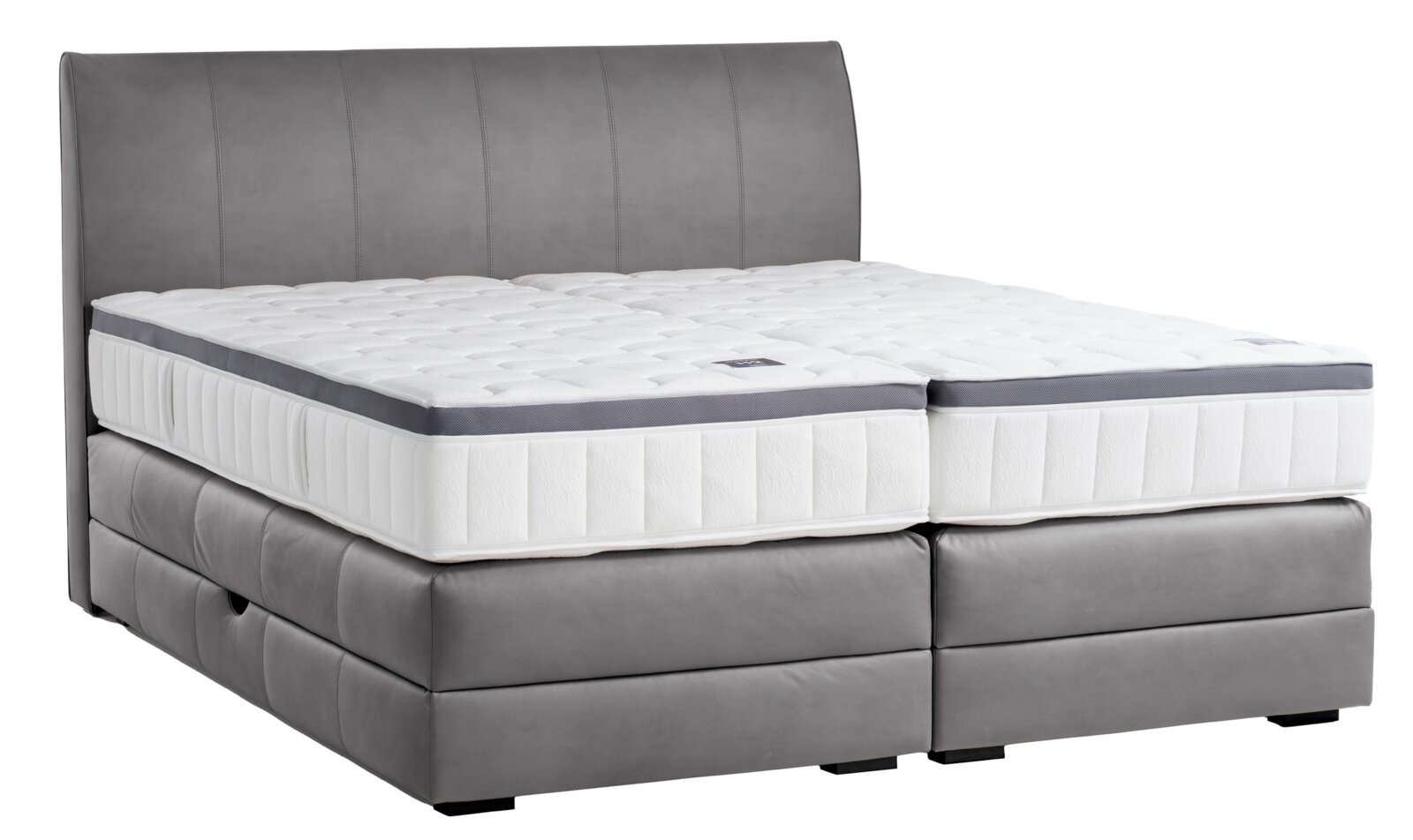 Boxspringbett in seitlicher Perspektive mit grauem Polster und weißer Matratze