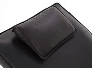 Nahaufnahme einer schwarzen Liege mit Kopfkissen, Perspektive von oben.