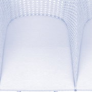 Nahaufnahme eines Armlehnstuhls mit geflochtenem Design und heller Polsterung, von oben betrachtet.