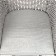 Nahaufnahme eines Armlehnstuhls mit geflochtenem Design und heller Polsterung, von oben betrachtet.