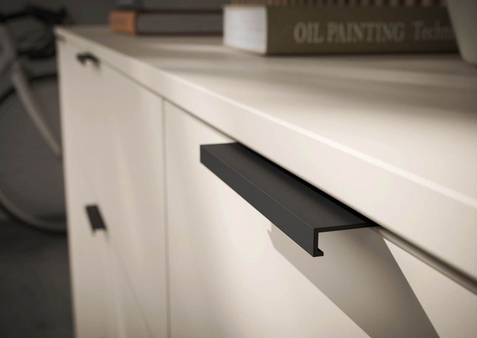 Nahaufnahme eines XL-Sideboards mit modernen schwarzen Griffen und einer glatten, hellen Oberfläche, seitliche Perspektive.