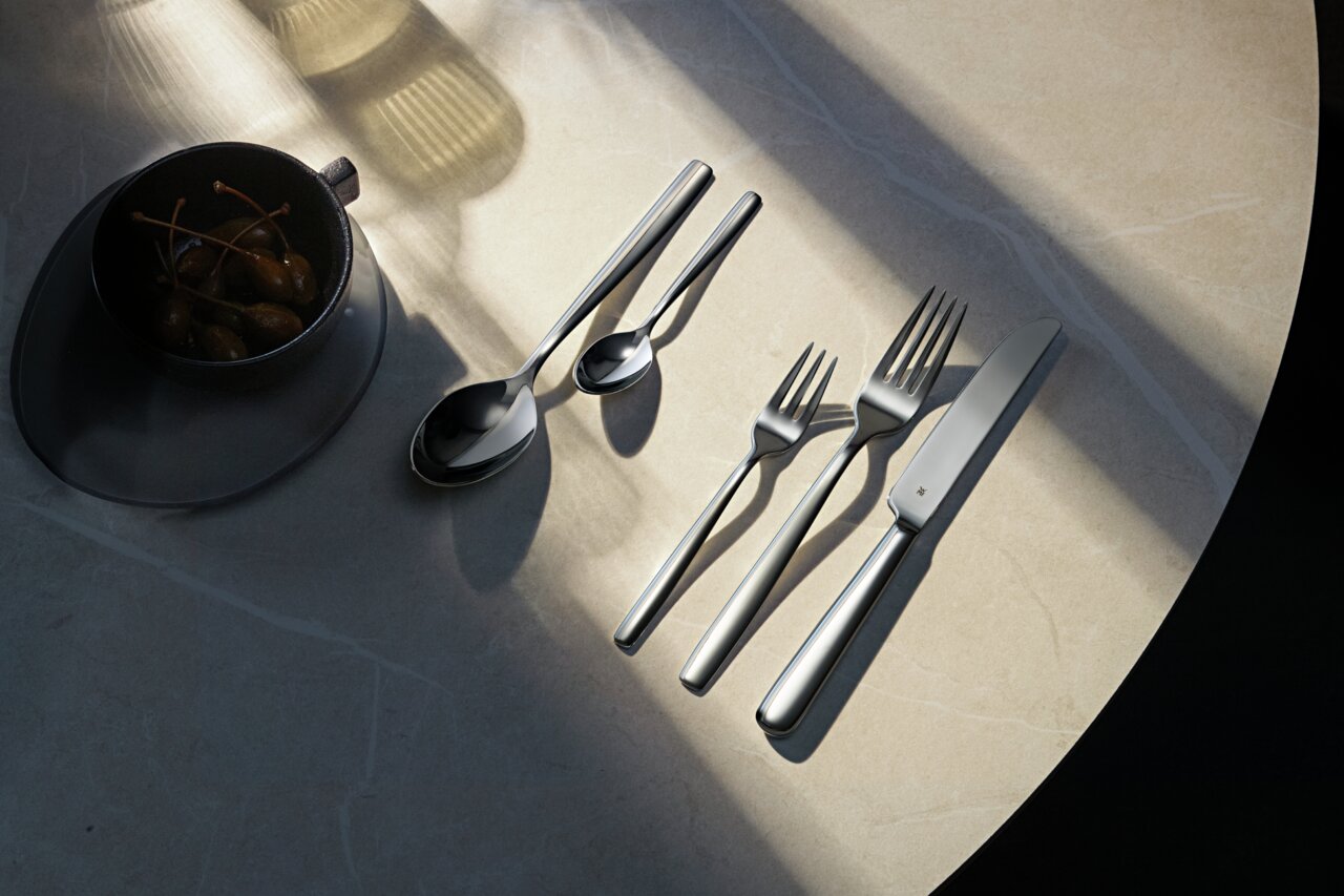 WMF Besteck-Set 30-tlg. PALMA Besteckset Palma 30-tlg. auf einem Tisch, bestehend aus Messer, Gabeln und Löffeln, von oben fotografiert.