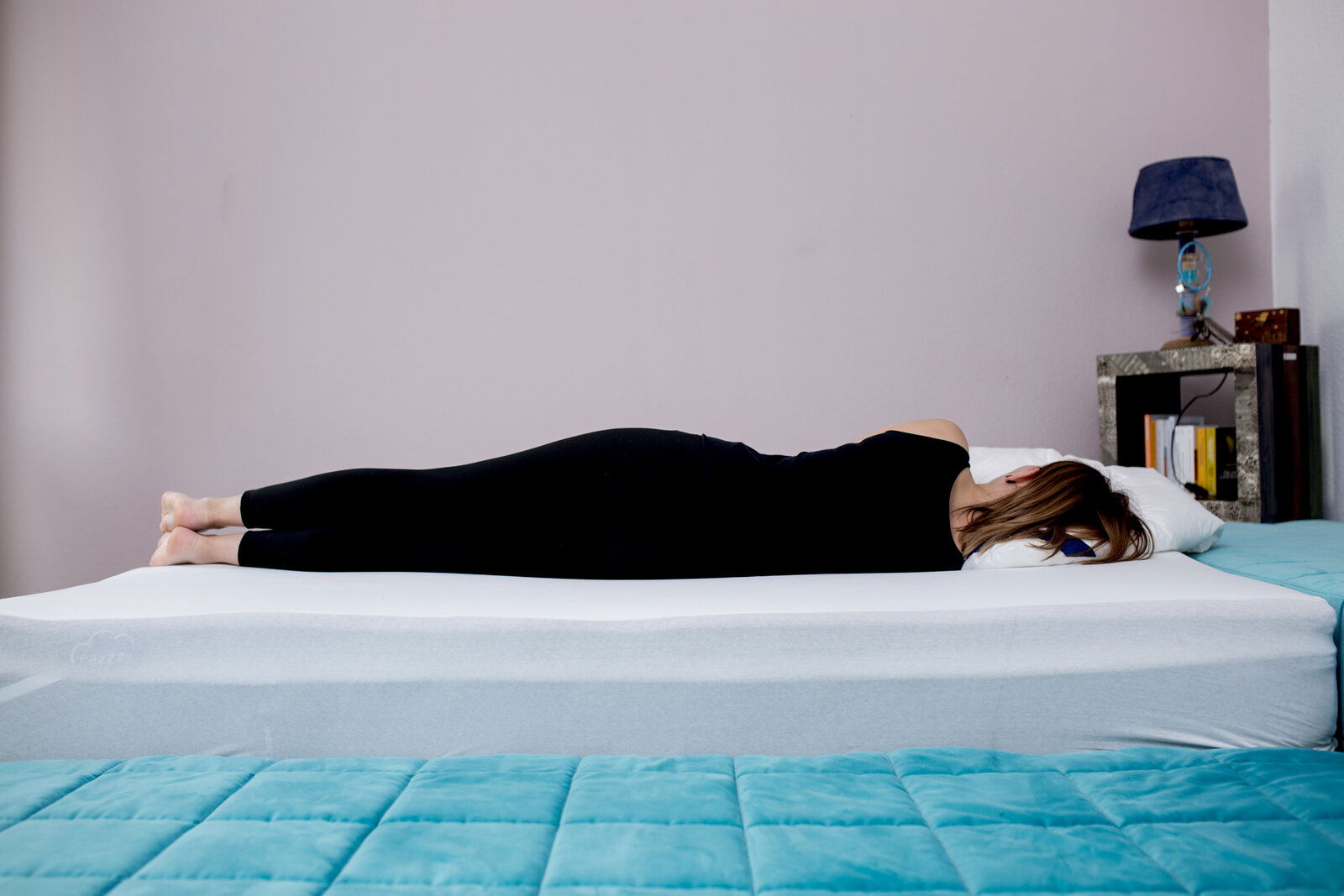 Genius Topper Classic 80x200cm EAZZZY Seitliche Ansicht eines EaZzzy Toppers Classic 80*200*7 mit einer Person, die bequem darauf liegt.