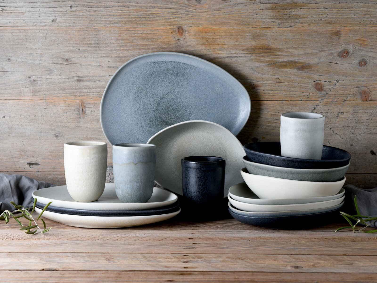 Creatable Suppenteller Set 4-tlg PIETRA Keramik-Geschirrset in Blau-, Grau- und Cremetönen mit Tellern, Schalen und Bechern auf rustikalem Holztisch, frontal in leichter Seitenansicht fotografiert