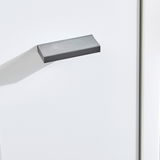 Nahaufnahme eines grauen Griffs an einer weißen Kommode, seitliche Perspektive