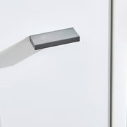 Nahaufnahme eines grauen Griffs an einer weißen Kommode, seitliche Perspektive