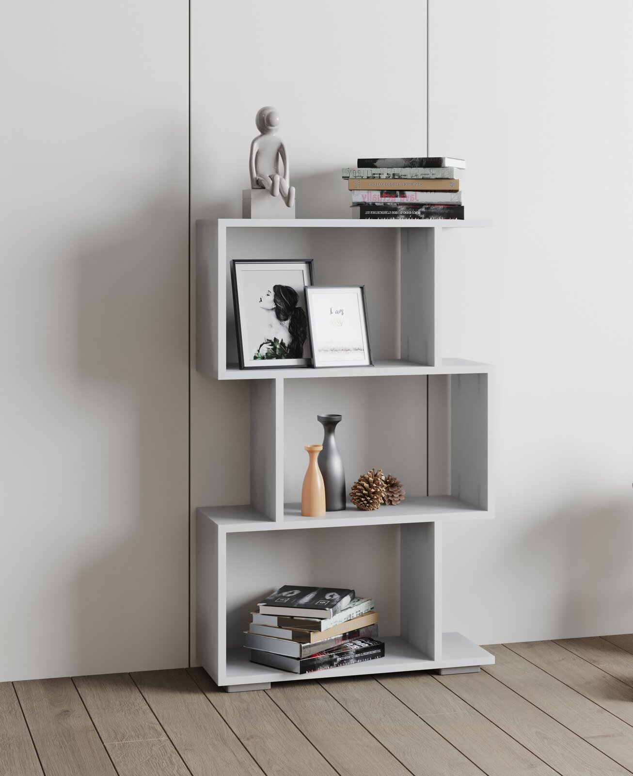 Modernes weißes Stufenregal mit asymmetrischen offenen Fächern, dekoriert mit Büchern, Bilderrahmen, Vasen und Zapfen, freistehend vor heller Wand; Perspektive: Frontalansicht auf Augenhöhe.