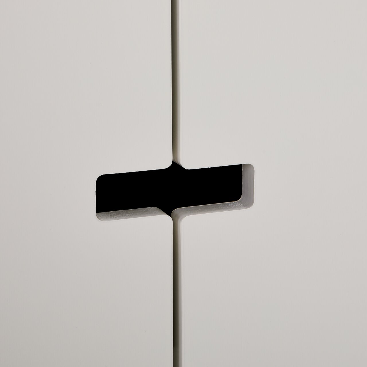 Nahaufnahme eines weißen Sideboards mit modernem Griffdesign, seitliche Perspektive.