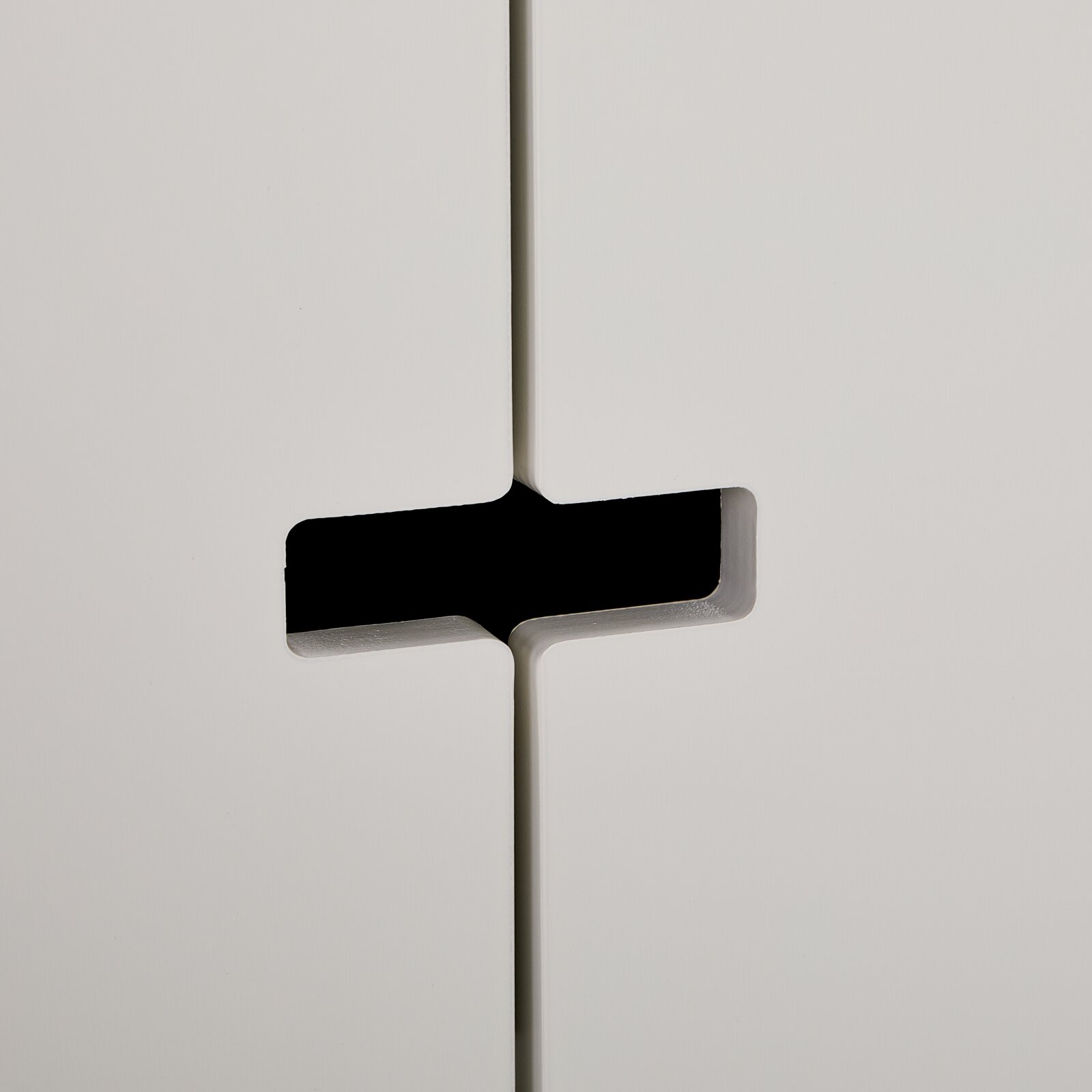 Nahaufnahme eines weißen Sideboards mit modernem Griffdesign, seitliche Perspektive.
