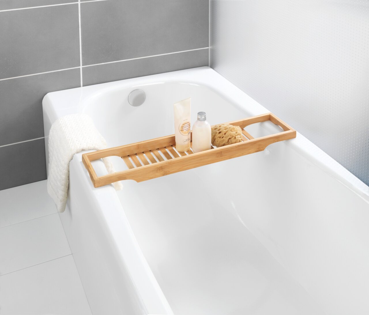Badewannenbrücke aus Bambus mit Pflegeprodukten und Schwamm, von oben fotografiert