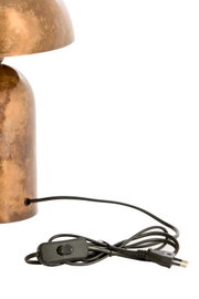 Detailaanzicht van een goudkleurige metalen tafellamp met verweerde afwerking, zwart snoer, snoerschakelaar en Europese stekker, vanaf de zijkant gefotografeerd
