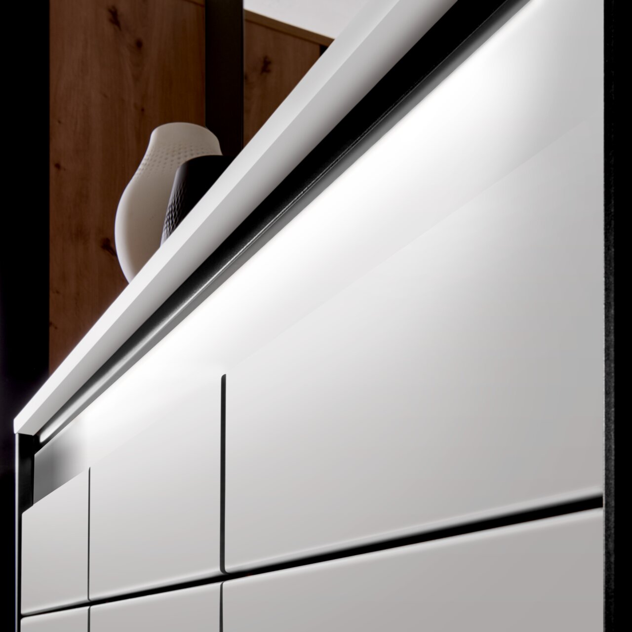 Nahaufnahme eines modernen XL-Schuhschranks mit weißen Fronten und eleganter Beleuchtung, seitliche Perspektive.