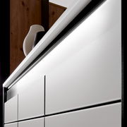 Nahaufnahme eines modernen XL-Schuhschranks mit weißen Fronten und eleganter Beleuchtung, seitliche Perspektive.