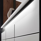 Nahaufnahme eines modernen XL-Schuhschranks mit weißen Fronten und eleganter Beleuchtung, seitliche Perspektive.