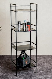 Schwarzes, schmales Metall-Standregal mit vier Ablagen, frontal in leichter Schrägansicht fotografiert, mit Toilettenartikeln und Filztasche dekoriert vor heller Wand auf Teppichboden.