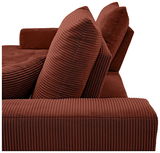 Nahaufnahme einer roten, gerippten Sofaecke mit zwei großen Kissen in Seitenansicht.