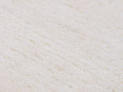 Nahaufnahme eines weißen Wollteppichs mit weicher, flauschiger Textur.