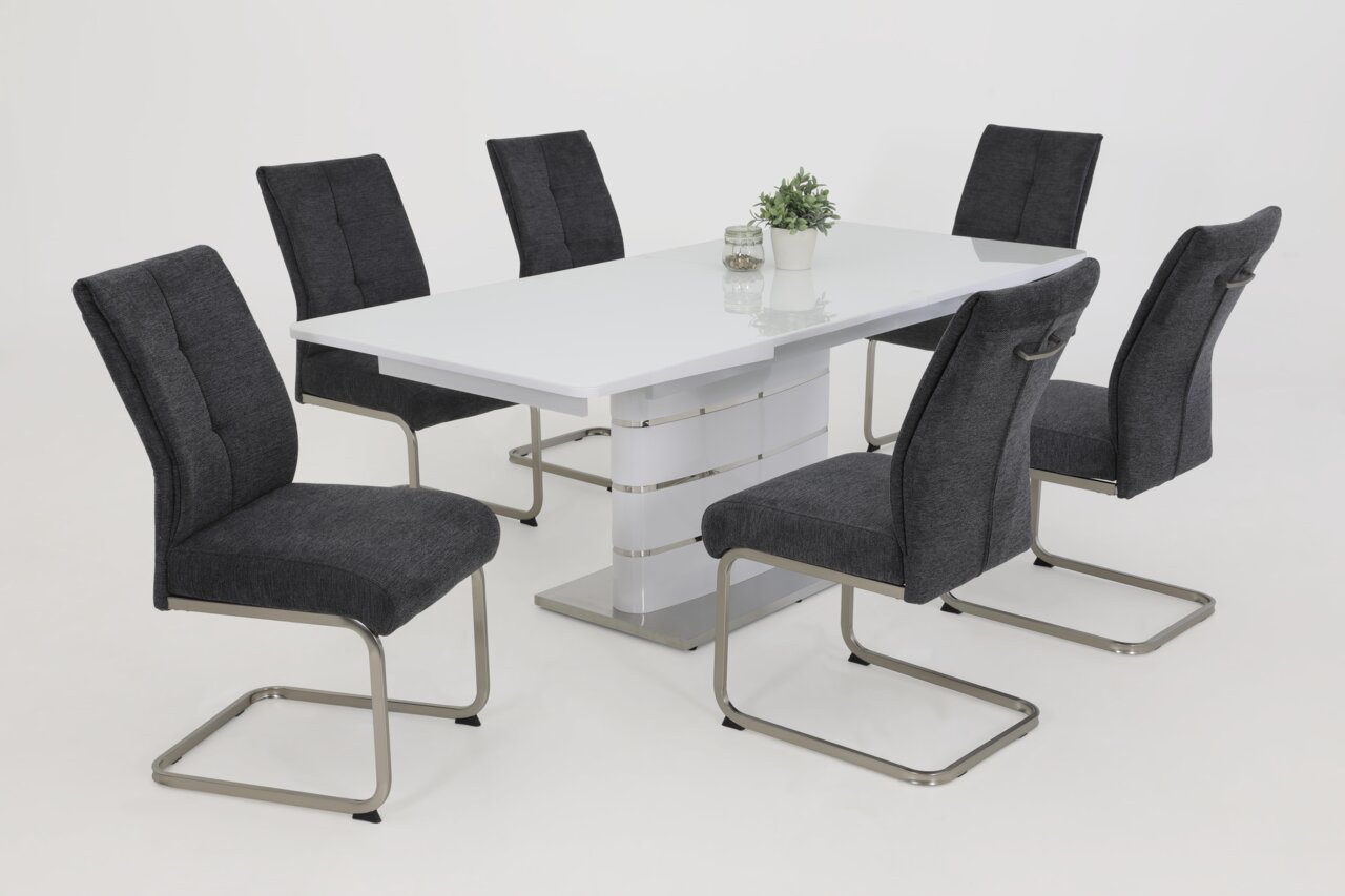 Esszimmer mit sechs modernen Schwingstühlen in Dunkelgrau um einen weißen Tisch, seitliche Perspektive.