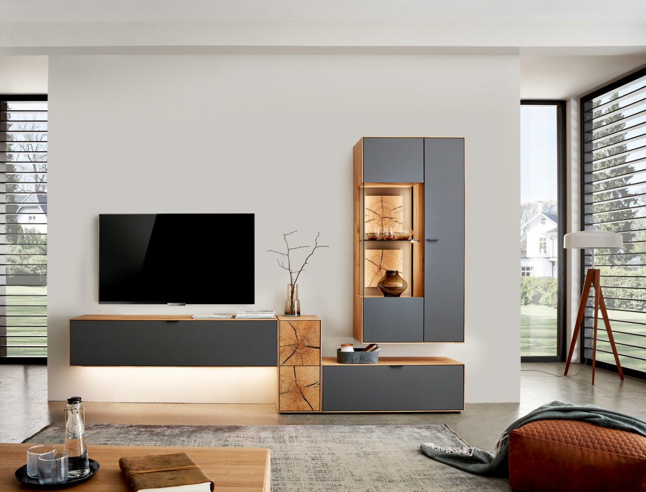 Moderne wandcombinatie in een woonkamer met grijze en houtkleurige elementen, bestaande uit een tv-meubel en een hangkast met verlichte planken. Perspectief: vooraanzicht.