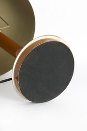 Nahaufnahme der Unterseite einer Tischleuchte mit runder, schwarzer Basis und braunem Stiel.